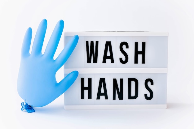 Wash your hands. Text on lightbox display with blue glove balloon on light table.