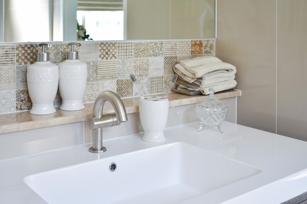 Washbasin with faucet and liquid soap bottle at home