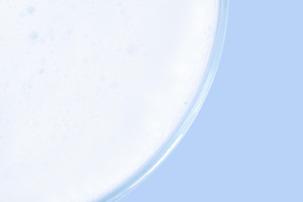 Washing agent foam in a Petri dish On a blue background