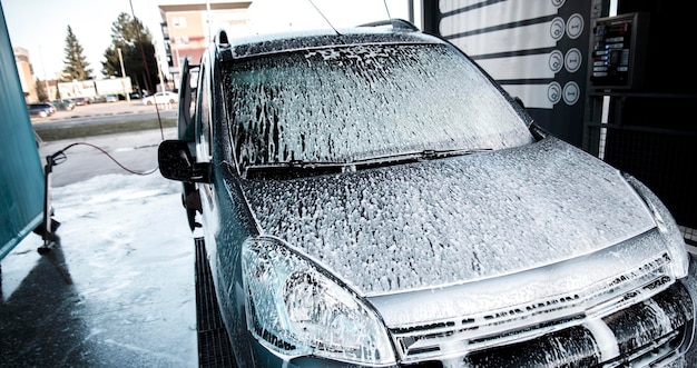 Washing car with soap. Close up clean car concept at car wash.