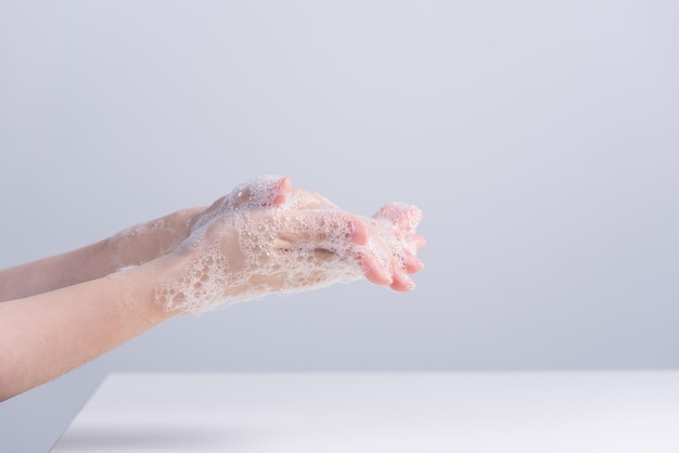 Washing hands Asian young woman using liquid soap to wash hands concept of hygiene to protective pandemic coronavirus isolated on gray white background close up