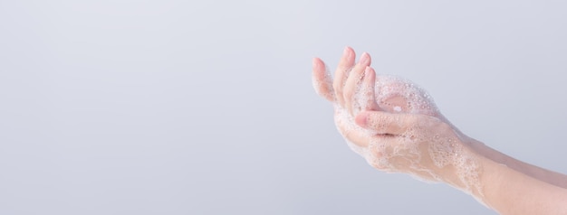 Washing hands Asian young woman using liquid soap to wash hands concept of hygiene to protective pandemic coronavirus isolated on gray white background close up