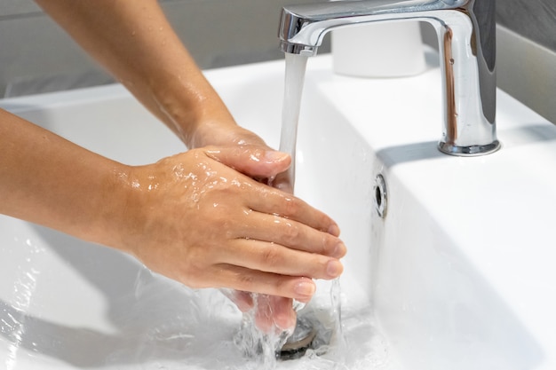 Washing hands rubbing with soap woman