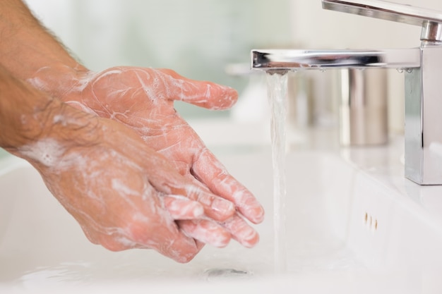 Washing hands with soap under running water