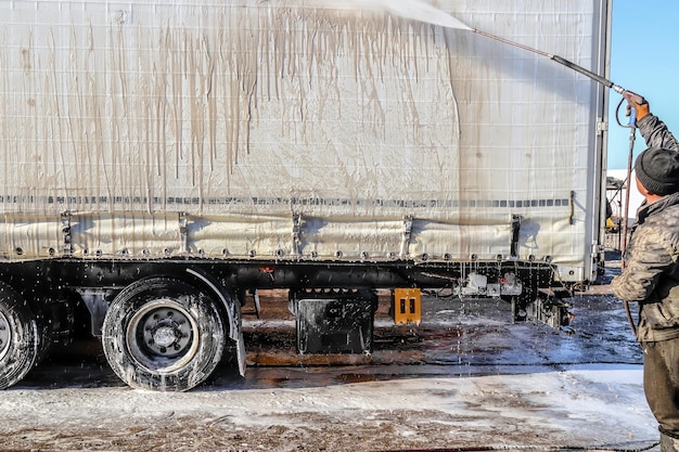 Washing a large truck with car shampoo Background for car service Truck washing outdoors Closeup Car wash with detergents