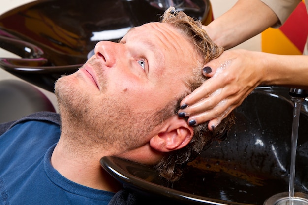 Washing man hair in beauty parlour hairdressing salon