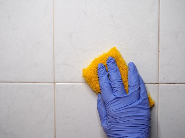 Washing white tiles with a yellow sponge