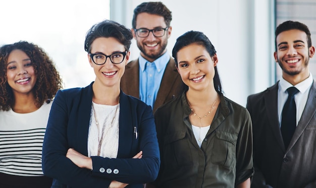 Watch us rise to the next level Portrait of a diverse team of professionals standing together in an office