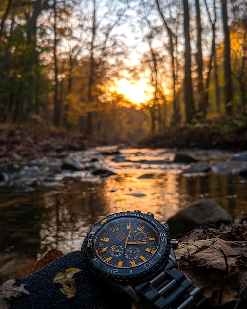 Photo a watch with the time of 11 55 is laying on a rock in a forest