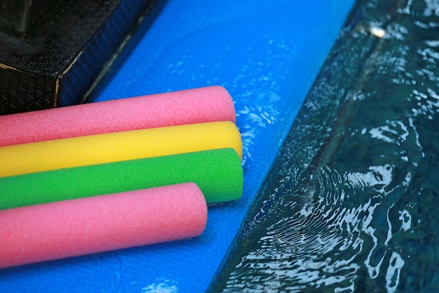 Photo water aerobic equipment. colored aqua noodles in swimming pool