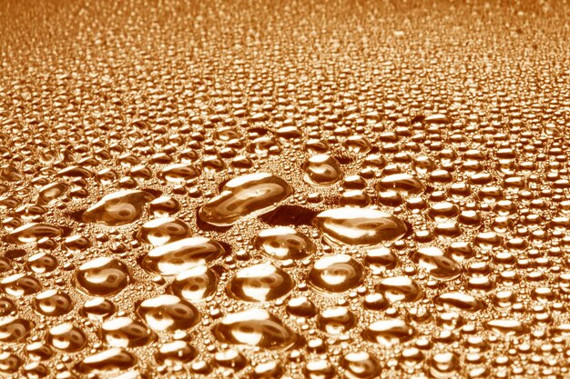 Water droplets on golden metal a beautiful unusual texture