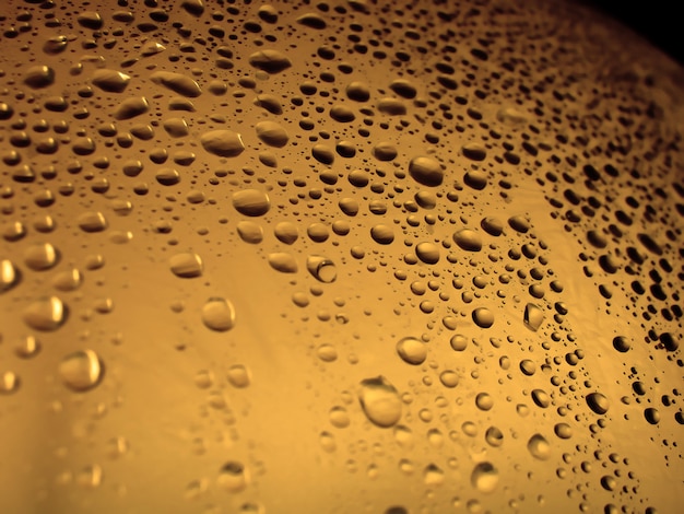 Water droplets on a plastic surface with a orange tone.