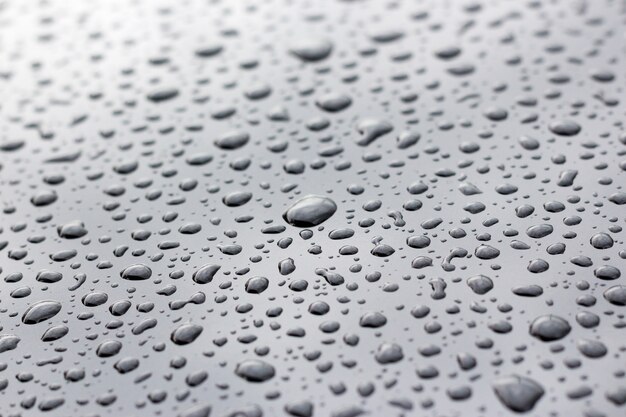 Water droplets on polished gray metallic surface as background