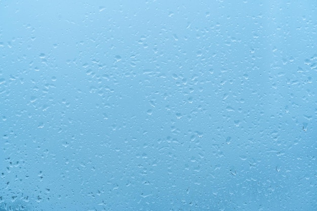 Water Drops Background Rain drops on window blue background Drops Of Rain Water at dawn with blue Light On Glass Background blue background drops glass abstract texture