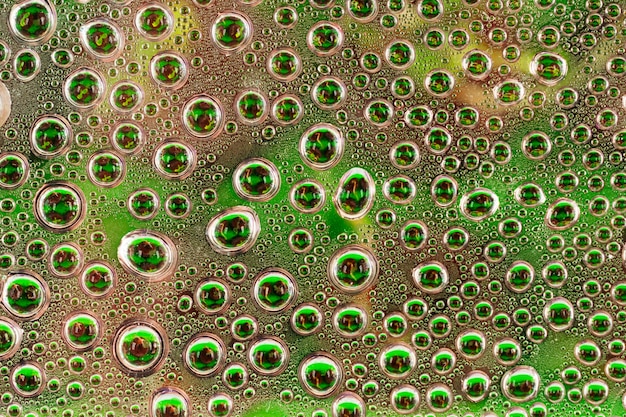 Water drops on green transparent glass