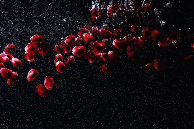 Water drops on ripe sweet pomegranate seeds. Fresh pomegranate background with copy space for your text. Vegan and vegetarian concept.