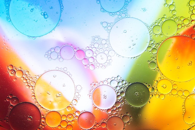 Water drops on transparent glass against multicolored background