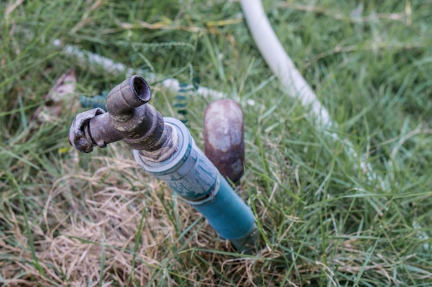 Water faucet with grass at outdoor house