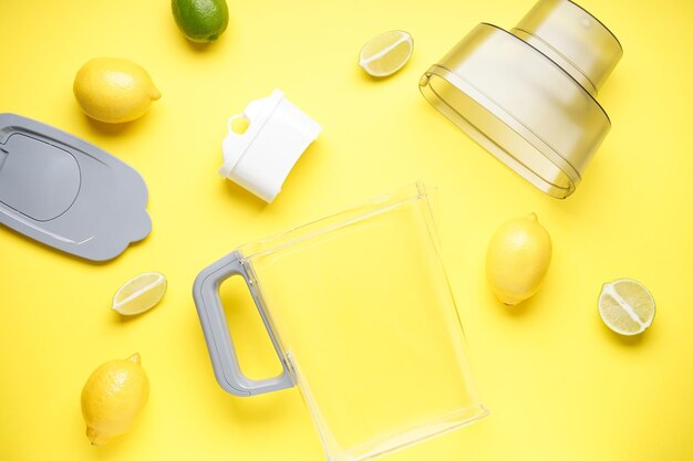 Water filter jug with lemon on a yellow background Top view