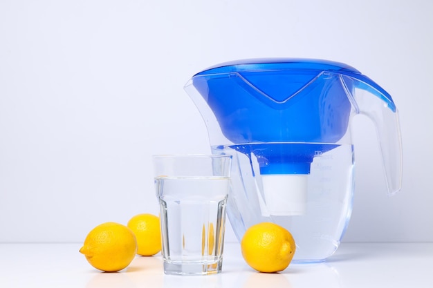 Water filter with fresh lemons and glass