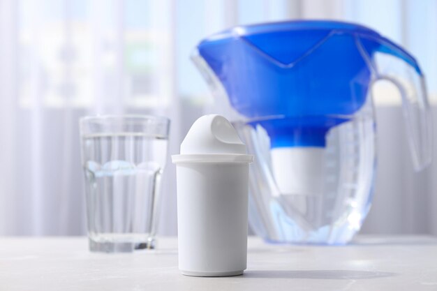 A water filter with a glass on a light background