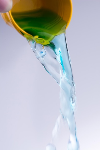 Water flowing out of little yellow bucket