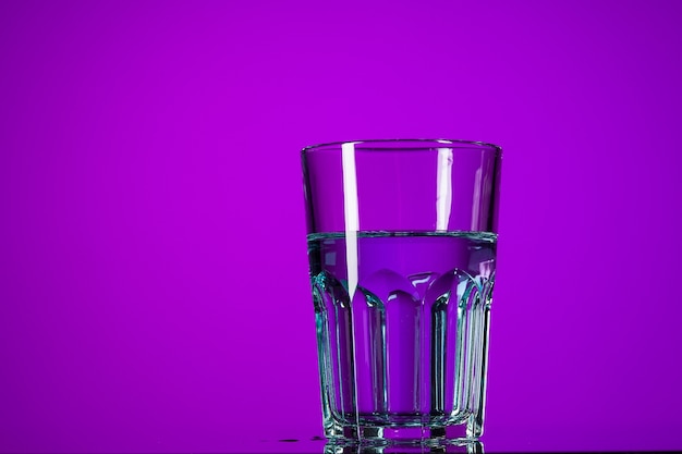 The water in glass on lilac background