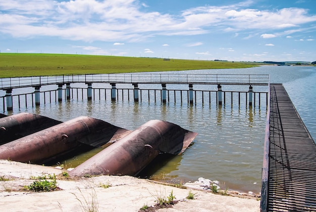 Water intake facilities river dam pipes and metal net platform at water reservoir