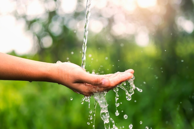 Water pouring on hand in morning ligth background