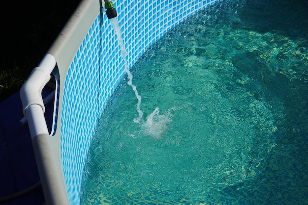 Water pours from a hose into a small round pool