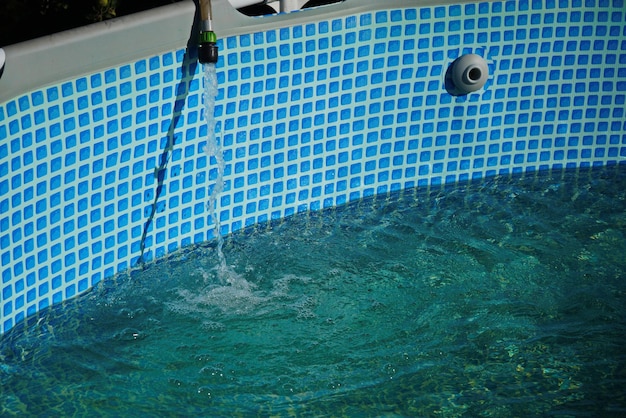 Water pours from a hose into a small round pool