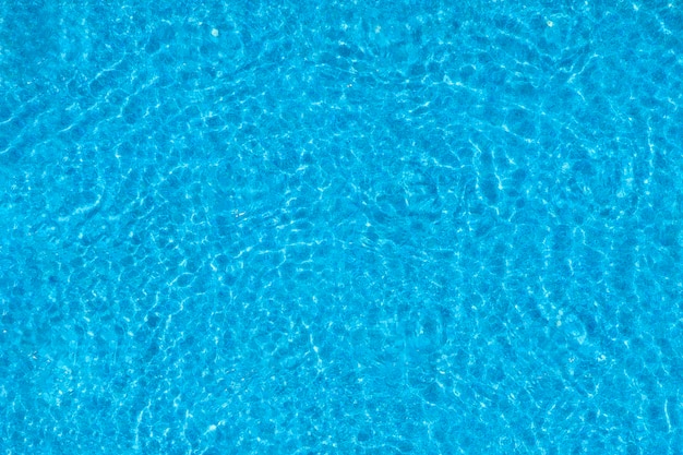 Water ripples on blue tiled swimming pool background Top view