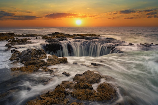 Water rushes into thors well in pacific ocean at sunset in oregon