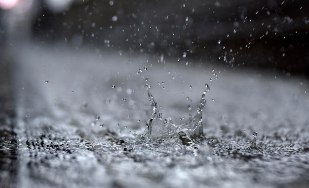 Water splash drops and droplets on pavement way from raining