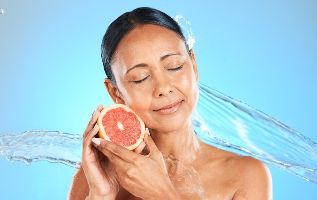 Water splash fruit and skincare wellness of a woman with a grapefruit feeling health and beauty Diet nutrition and healthy skin of a model with natural organic produce feeling calm and peace