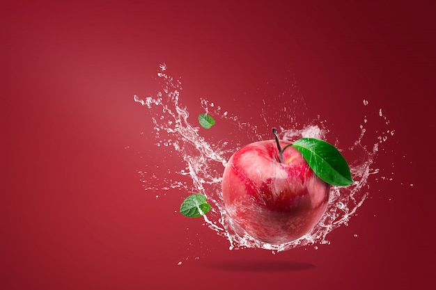 Water splashing on Fresh Red apple on red 