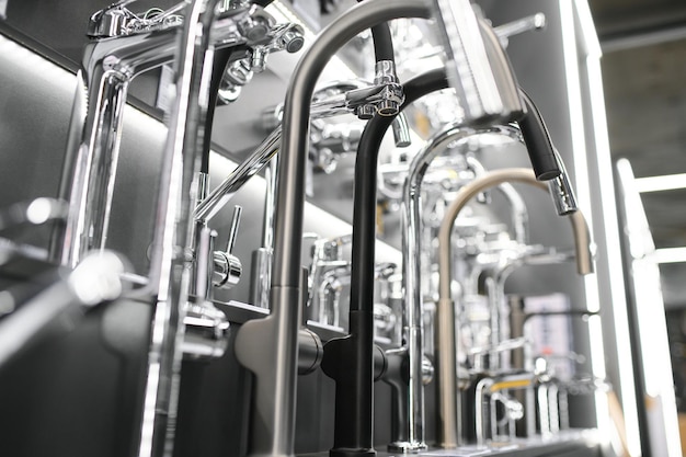 Water taps of different types and shapes on the counter in the store Retail trade in sanitary ware Foreground