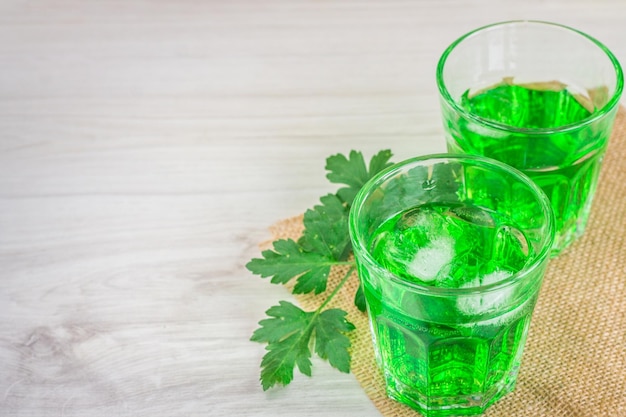 Water with tarragon on a wooden surface