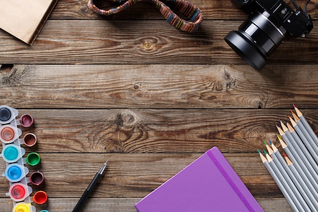 Photo watercolors, color pencils and sketchbook on wooden table. flat lay photo with empty space for logo, text.