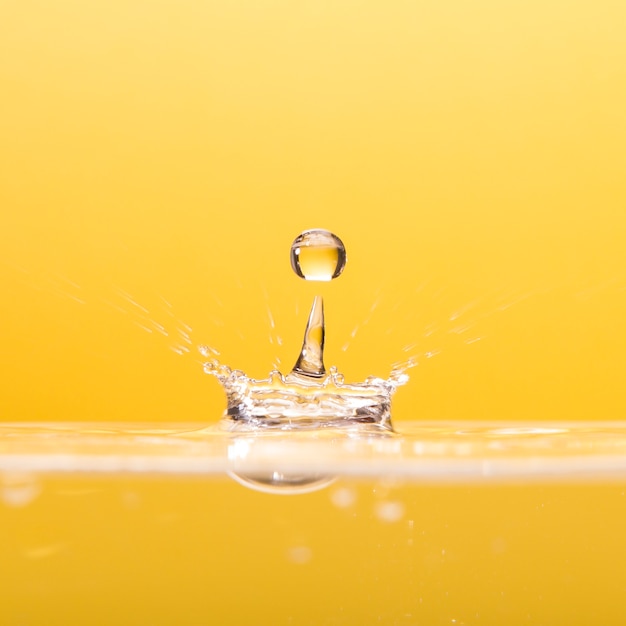 Waterdrop falling on yellow