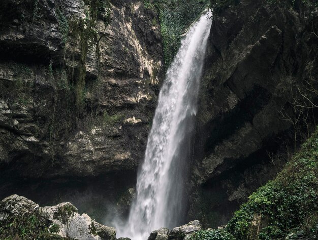 Waterfall flowing from rocky stone wall