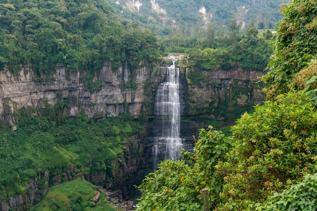 Waterfall in a forest with mountains