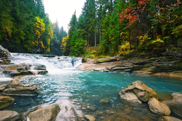 Waterfall on mountain river with blue water