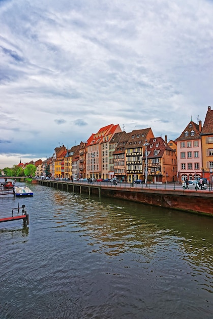 Waterfront of Ill River and half-timbered houses in Quai des Bateliers Quay in the old town in Strasbourg, Grand East region in France. People on the background