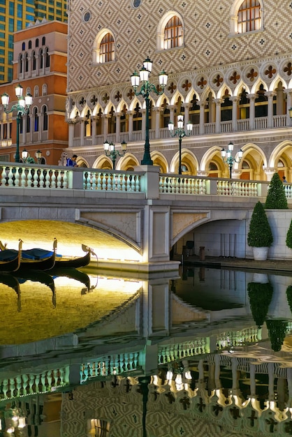 Waterfront in Venetian Macau Casino and Hotel, luxury resort in Macao, China. People on the background. Late in the evening. Golden light illumination