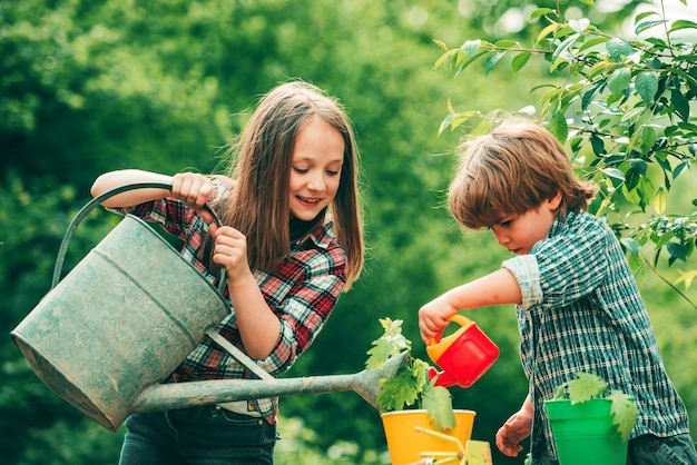 Photo watering flowers in garden kids planting flowers in pot children farmer in the farm with countryside