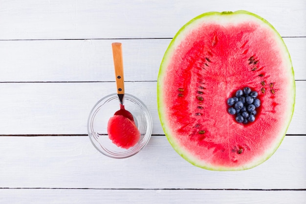 Watermelon and blueberries on white background The process of eating watermelon with spoon