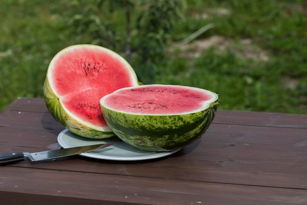 Watermelon cut in half on a table outside in the hot summer