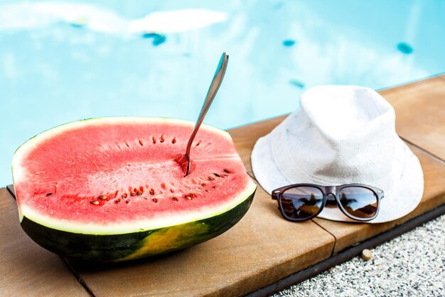 Watermelon and glasses near the pool