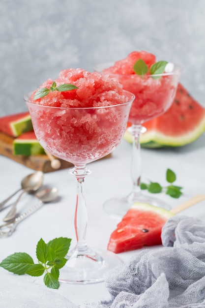 Watermelon granite with mint, summer refreshing drink in glass on a gray concrete background. Selective focus.